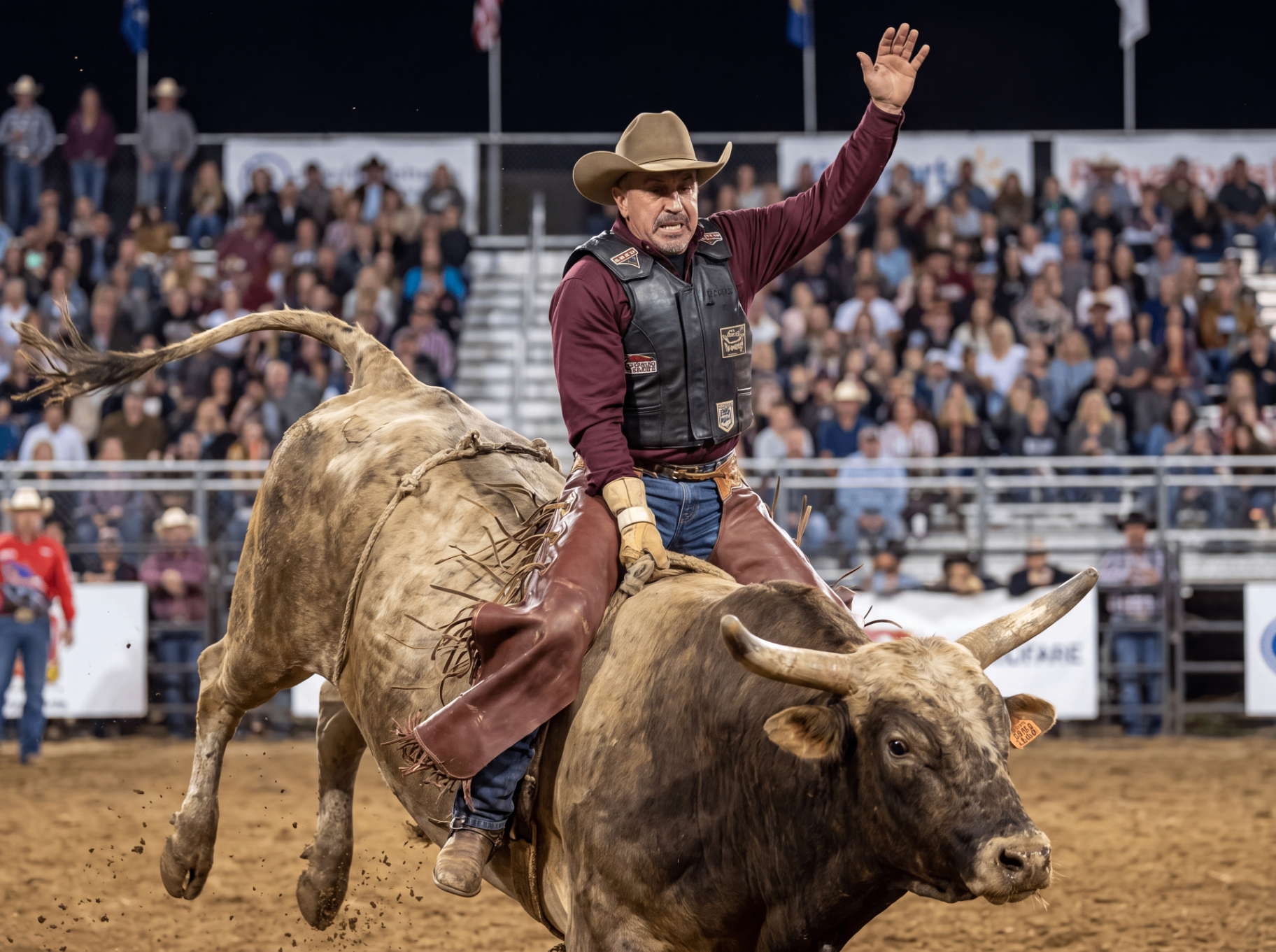 Dan waving while riding a bull at a rodeo